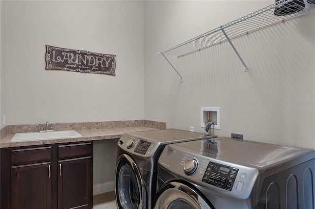 laundry room with cabinets, washer and clothes dryer, and sink