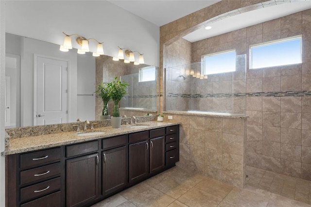 bathroom with vanity, tiled shower, and tile patterned floors