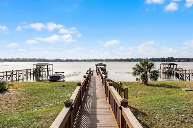 dock area with a lawn and a water view