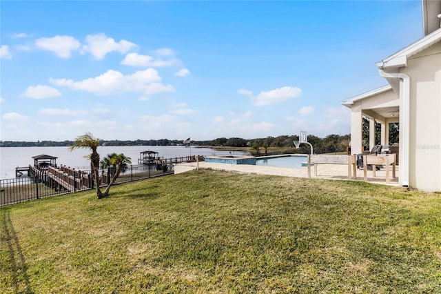 view of yard with a fenced in pool, a water view, and a patio area