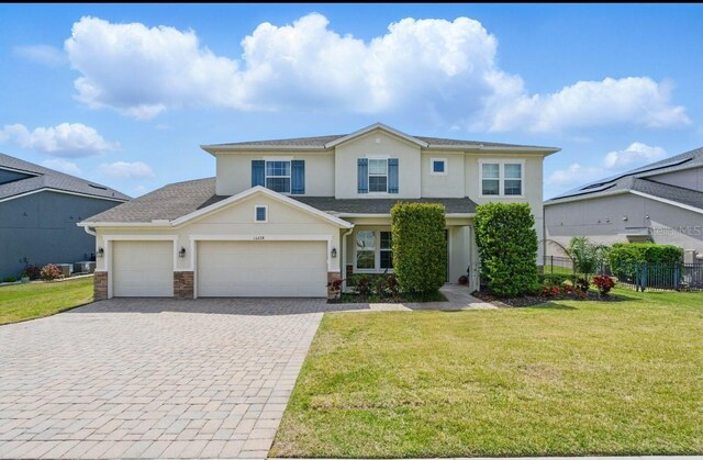 16428 Good Hearth Blvd, Clermont, FL 34711 - view of front of property featuring decorative driveway, stucco siding, a garage, stone siding, and a shingled roof