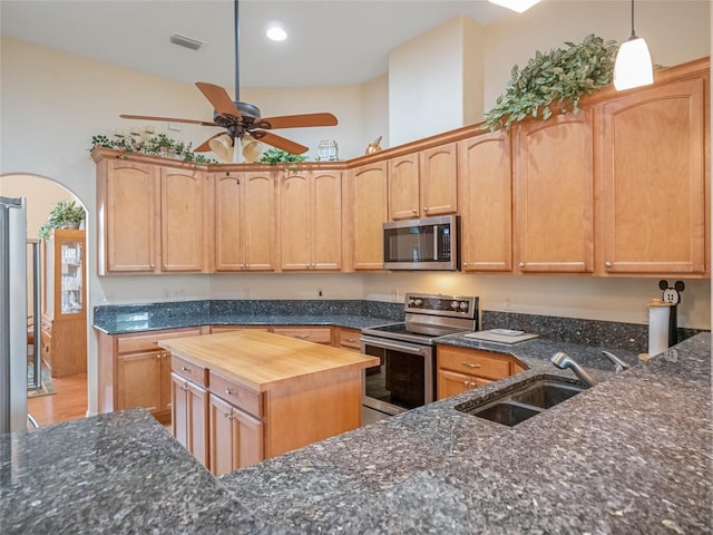 kitchen with wooden counters, light brown cabinetry, appliances with stainless steel finishes, and sink