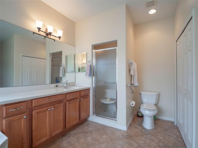 bathroom with toilet, tile patterned floors, a shower with shower door, and vanity