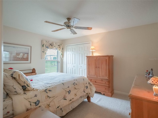 carpeted bedroom featuring ceiling fan and a closet