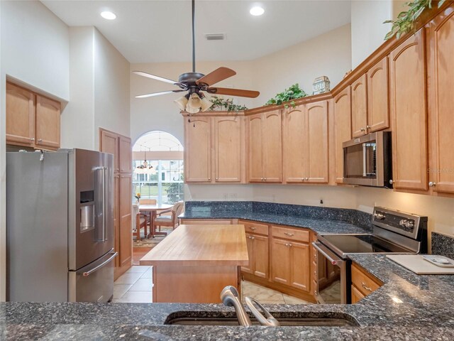 27504 Stoney Brook Dr, Leesburg, FL 34748 - kitchen featuring appliances with stainless steel finishes, a ceiling fan, dark stone countertops, a sink, and recessed lighting