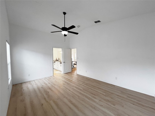 empty room with lofted ceiling, ceiling fan, and light hardwood / wood-style floors