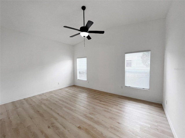 unfurnished room with ceiling fan, vaulted ceiling, a wealth of natural light, and light hardwood / wood-style flooring