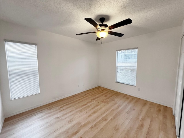 spare room with ceiling fan, a textured ceiling, and light wood-type flooring