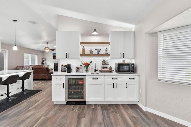 bar featuring pendant lighting, white cabinets, lofted ceiling, wine cooler, and decorative backsplash