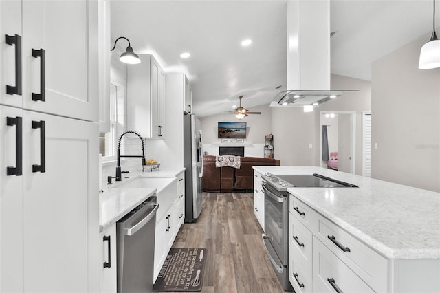 kitchen featuring hanging light fixtures, island exhaust hood, stainless steel appliances, and white cabinetry