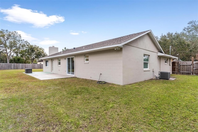 rear view of house with a lawn, cooling unit, and a patio area