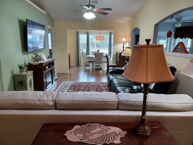 living room with ceiling fan, wood-type flooring, and lofted ceiling