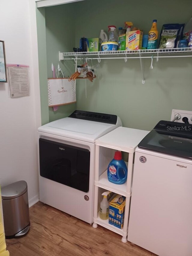 laundry room featuring separate washer and dryer and hardwood / wood-style floors