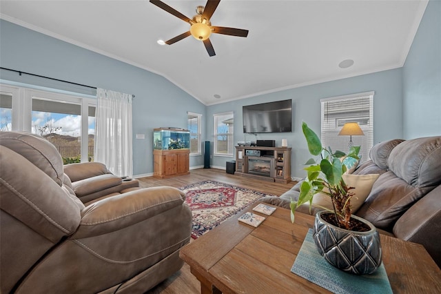 living room featuring crown molding, baseboards, lofted ceiling, wood finished floors, and a ceiling fan