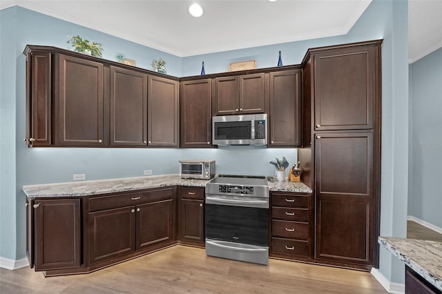 kitchen featuring light stone counters, dark brown cabinets, light wood finished floors, and stainless steel appliances