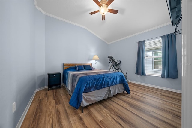 bedroom featuring a ceiling fan, wood finished floors, crown molding, baseboards, and vaulted ceiling