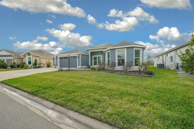 view of front of house featuring cooling unit, an attached garage, concrete driveway, and a front lawn