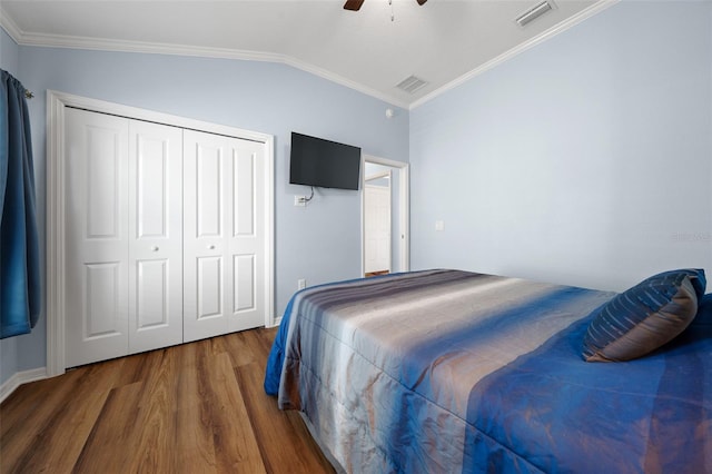 bedroom featuring visible vents, crown molding, lofted ceiling, and wood finished floors