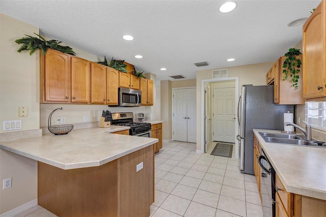 kitchen with sink, a textured ceiling, light tile patterned floors, kitchen peninsula, and stainless steel appliances