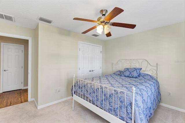 carpeted bedroom featuring a closet and ceiling fan