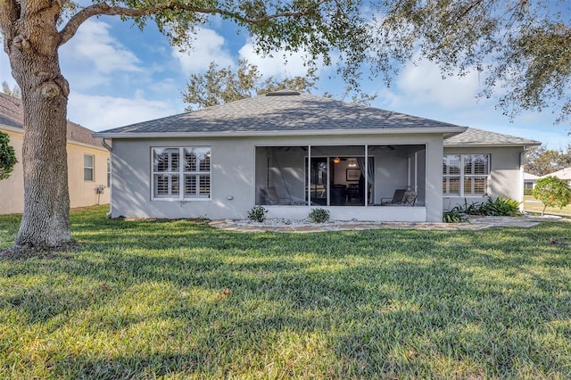 rear view of property with a sunroom and a lawn