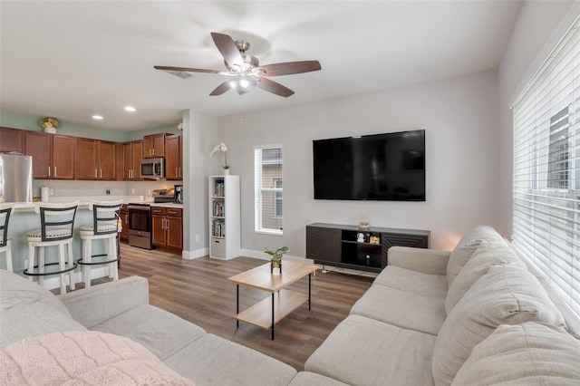 living room with ceiling fan and dark hardwood / wood-style floors