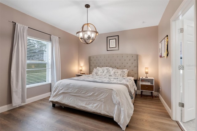 bedroom featuring light hardwood / wood-style flooring and an inviting chandelier