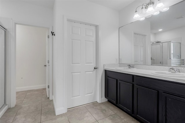 bathroom featuring a notable chandelier, tile patterned floors, vanity, and a shower with shower door