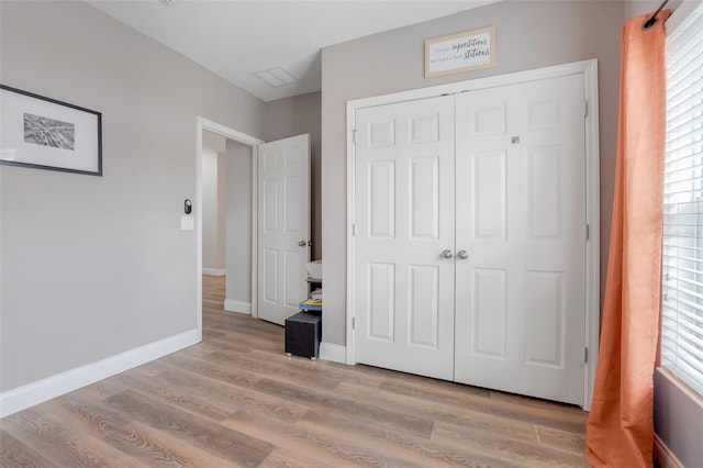 unfurnished bedroom with light hardwood / wood-style floors and a closet