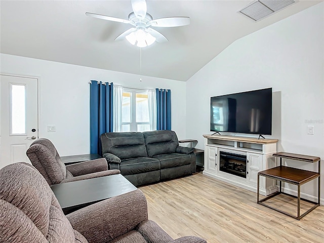 living room featuring light hardwood / wood-style floors, ceiling fan, and vaulted ceiling