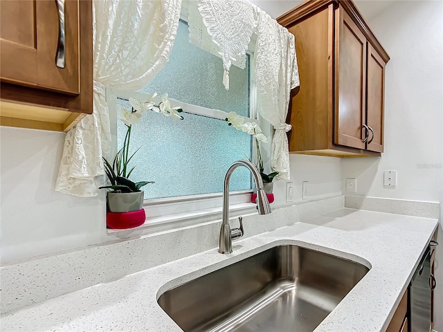 details with stainless steel dishwasher, light stone counters, and sink