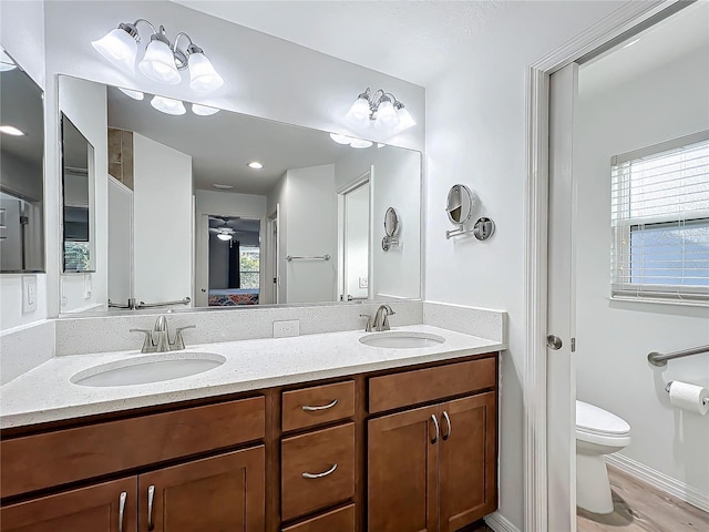 bathroom featuring toilet, vanity, and hardwood / wood-style floors