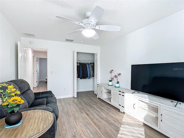 living room with ceiling fan and light hardwood / wood-style flooring