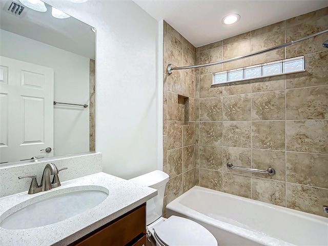 full bathroom featuring toilet, vanity, and tiled shower / bath combo