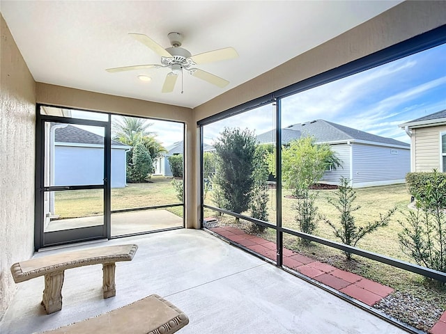 unfurnished sunroom featuring ceiling fan