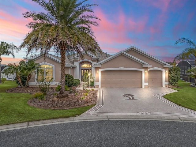 view of front of property with a yard and a garage