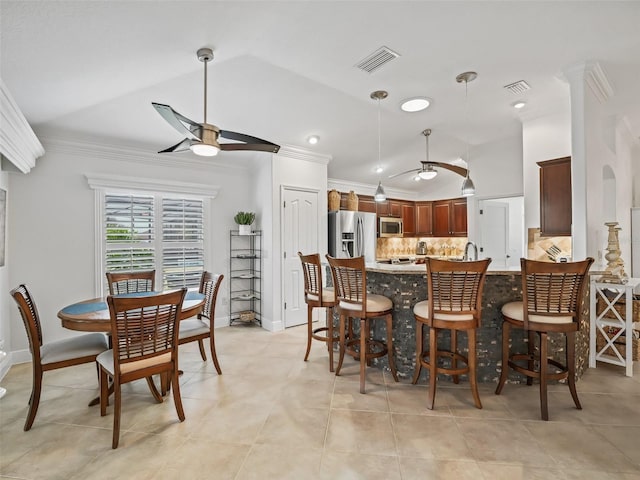 dining room with ornamental molding, lofted ceiling, sink, and ceiling fan