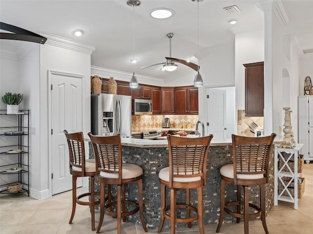 kitchen with pendant lighting, stainless steel appliances, a kitchen breakfast bar, and ceiling fan