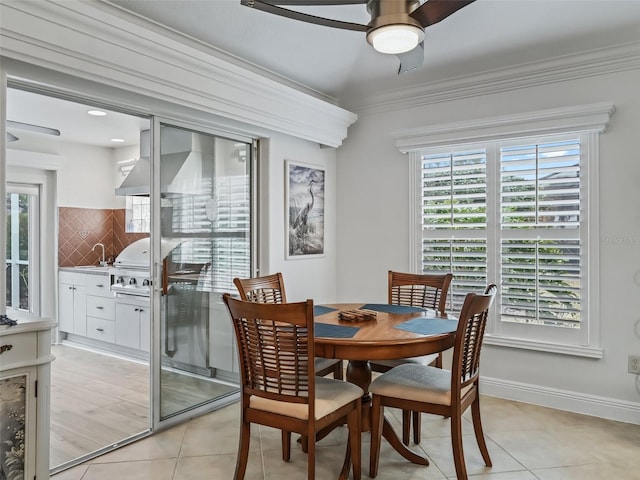 tiled dining space featuring ceiling fan, ornamental molding, and sink