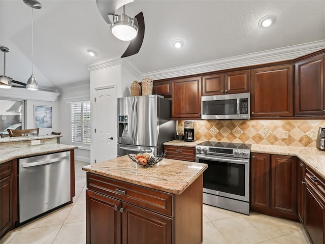 kitchen with light stone counters, stainless steel appliances, decorative light fixtures, and backsplash