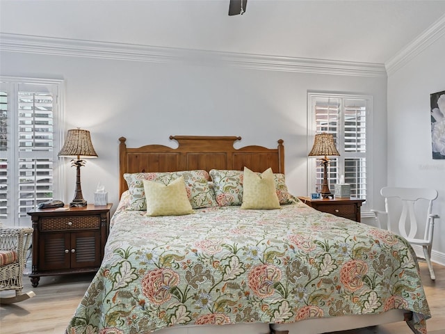 bedroom featuring ceiling fan, ornamental molding, light hardwood / wood-style floors, and multiple windows