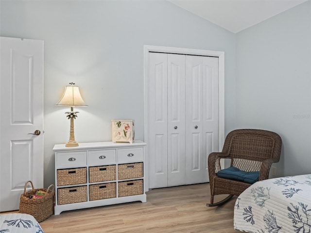 bedroom featuring lofted ceiling, light hardwood / wood-style flooring, and a closet