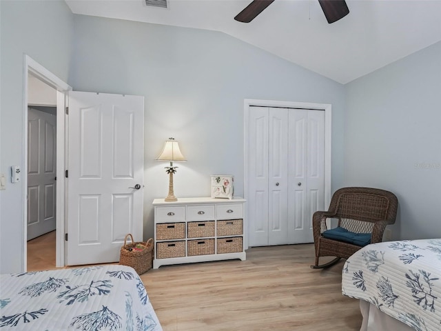 bedroom featuring light hardwood / wood-style floors, lofted ceiling, ceiling fan, and a closet