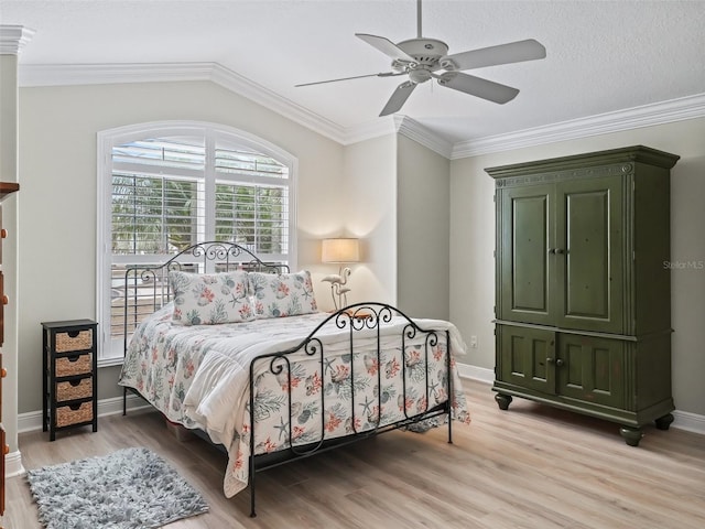 bedroom featuring crown molding, light hardwood / wood-style flooring, ceiling fan, and vaulted ceiling