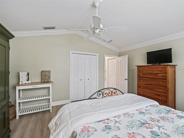 bedroom featuring crown molding, lofted ceiling, hardwood / wood-style floors, and ceiling fan