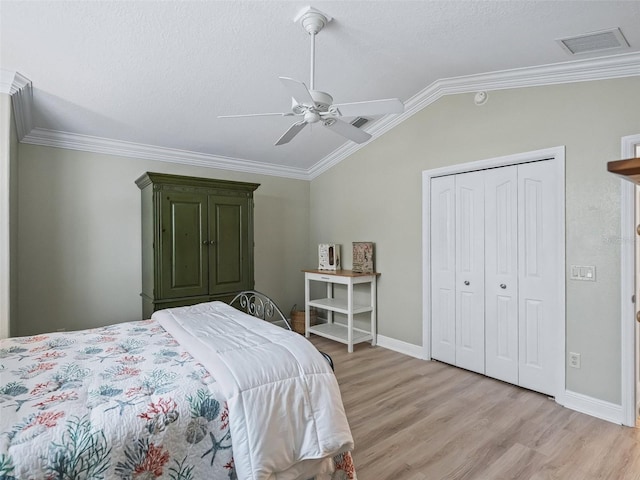 bedroom with lofted ceiling, ornamental molding, a closet, and ceiling fan