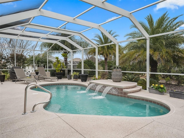 view of pool featuring a patio area, pool water feature, and glass enclosure