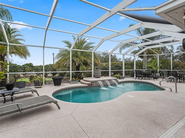 view of swimming pool with pool water feature, a patio area, and glass enclosure