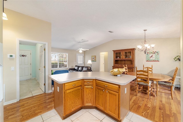 kitchen featuring lofted ceiling, hanging light fixtures, a center island, and light wood-type flooring