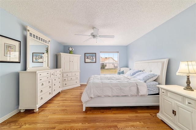 bedroom featuring a textured ceiling, light hardwood / wood-style flooring, and ceiling fan